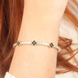 Elegant 14K gold bangle bracelet featuring black onyx stones, a flexible design, and a luxurious, modern look.