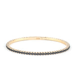 A close-up of an Onyx tennis bracelet in gold, highlighting its refined craftsmanship and elegant appeal.
