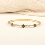 A beautifully handcrafted black onyx clover bracelet with a minimalist gold design, worn as a statement piece.
