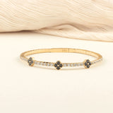 A beautifully handcrafted black onyx clover bracelet with a minimalist gold design, worn as a statement piece.