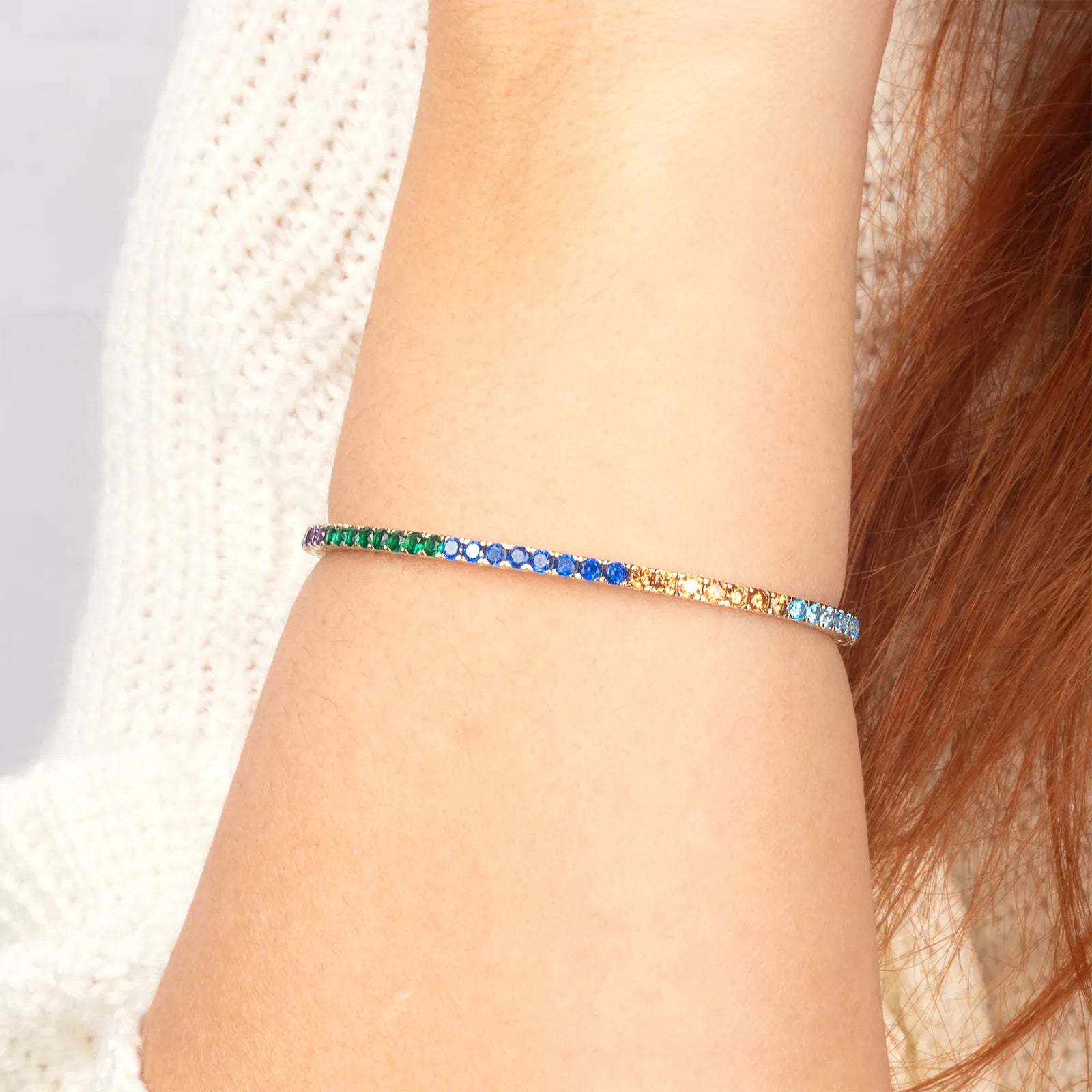 A delicate and flexible 14K gold rainbow gemstone bracelet, adding a subtle yet striking pop of color to any outfit.