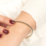 Minimalist gold bracelet featuring a row of stunning black diamonds, designed for those who appreciate timeless elegance and luxury.