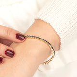 Minimalist gold bracelet featuring a row of stunning black diamonds, designed for those who appreciate timeless elegance and luxury.