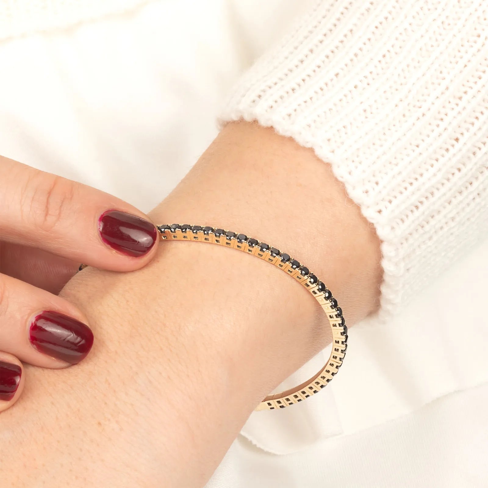 Minimalist gold bracelet featuring a row of stunning black diamonds, designed for those who appreciate timeless elegance and luxury.