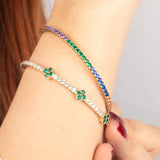 A model wearing14K gold tennis bracelet with a vivid array of gemstones, elegantly styled for a refined look.