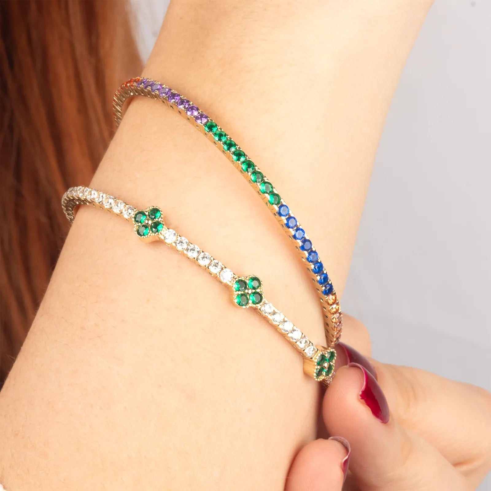 A model wearing14K gold tennis bracelet with a vivid array of gemstones, elegantly styled for a refined look.
