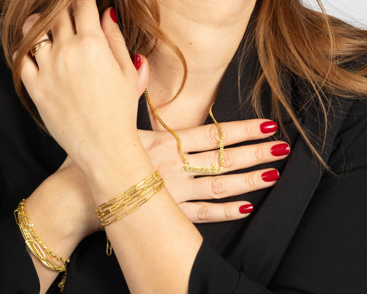 Woman wearing stackable gold bracelets and a personalized name necklace, showcasing elegant handcrafted jewelry from MyJewelist.