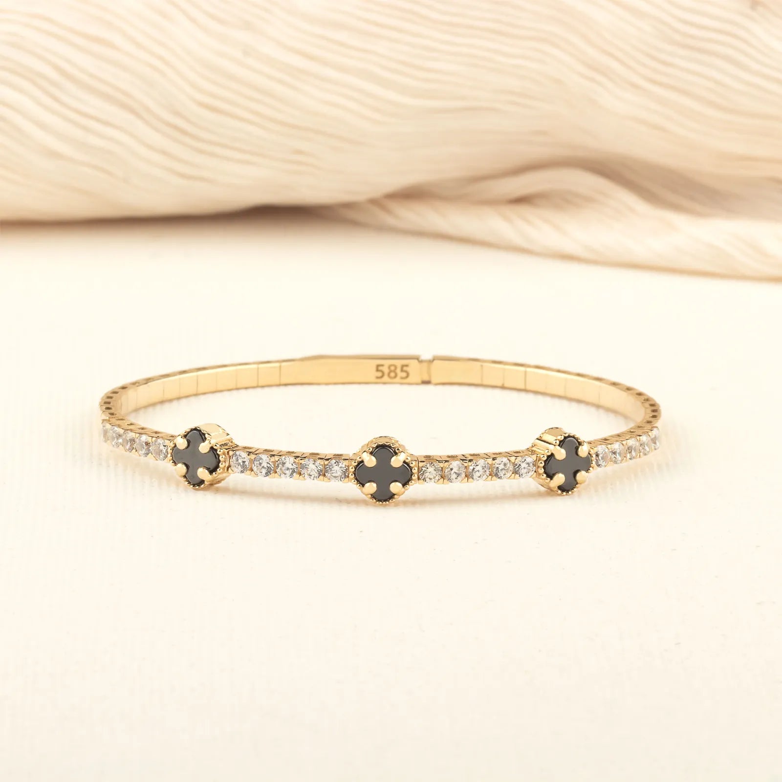clovre gold bracelet featuring black onyx stones in a flexible, comfortable design for a timeless and sophisticated look.