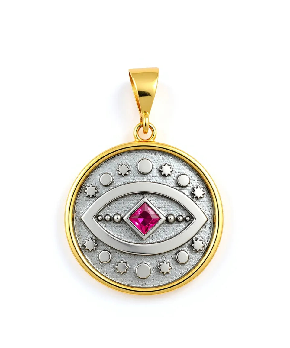 Gold and silver pendant with a red gemstone on a white background