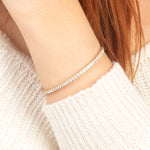 A radiant gold moissanite tennis bracelet, gracefully wrapped around a wrist, perfect for everyday elegance or special occasions.