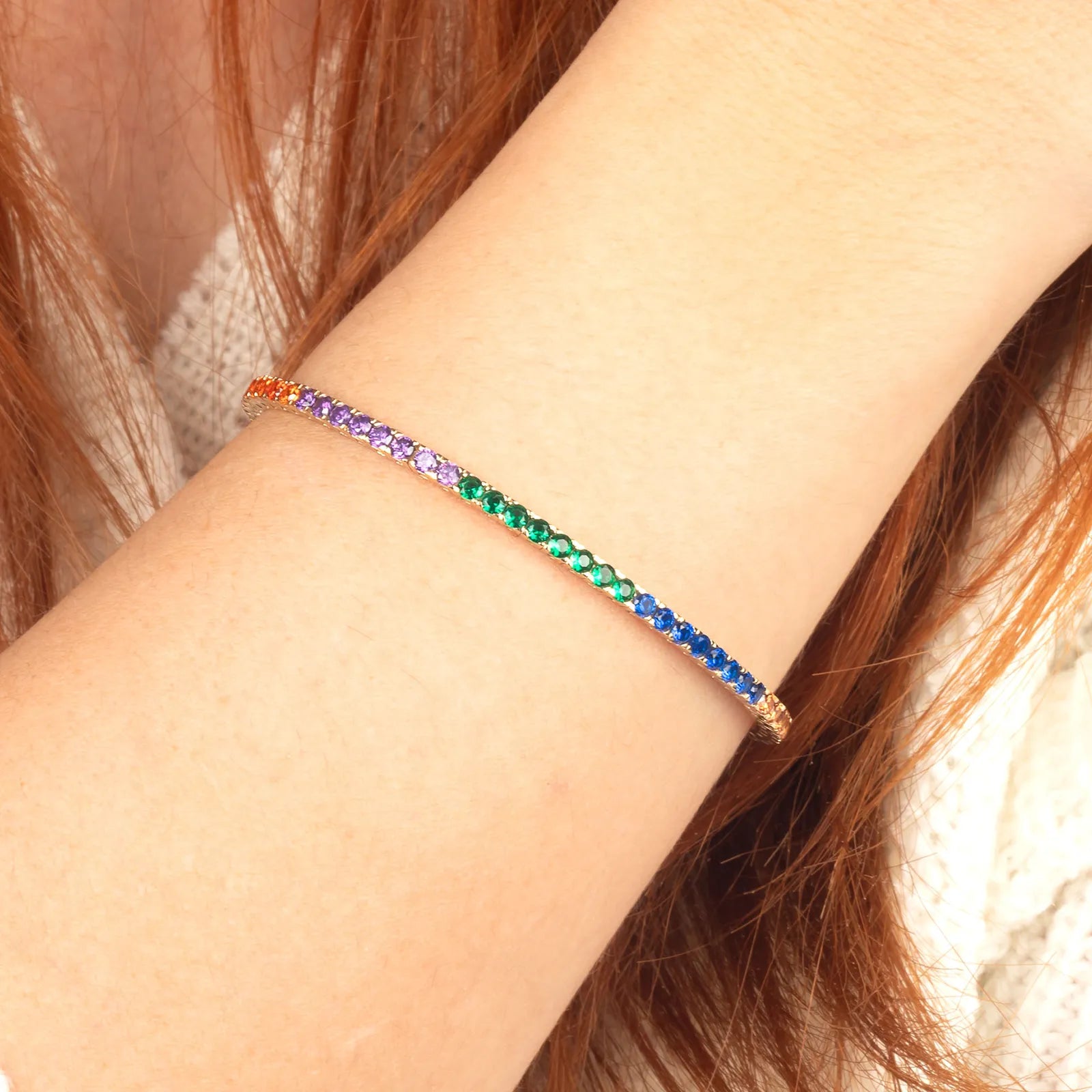 14K gold tennis bracelet featuring a gradient of vibrant gemstones, creating a stunning rainbow effect.
