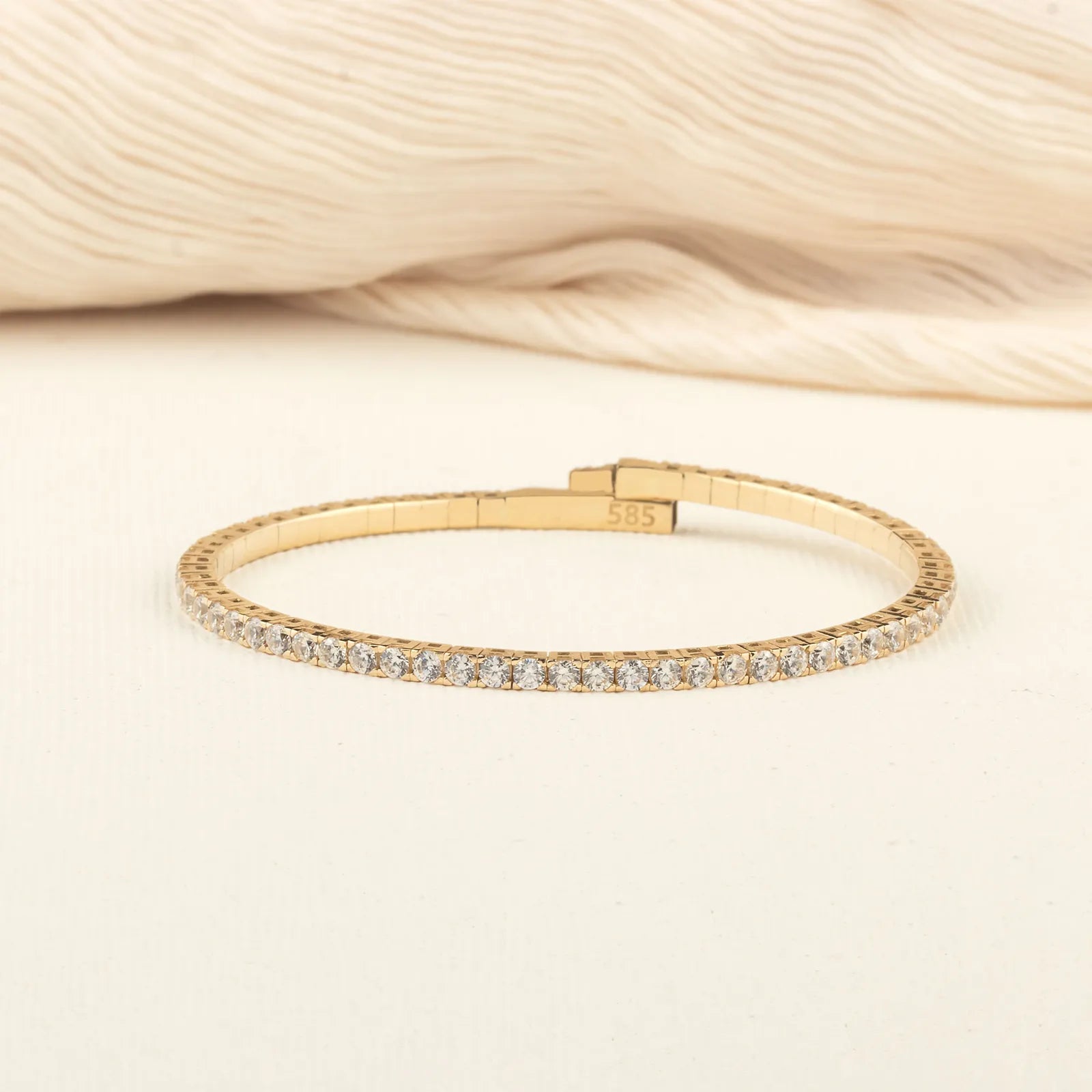 A close-up of a 14K gold moissanite tennis bracelet, highlighting its sleek and flexible design for effortless luxury.