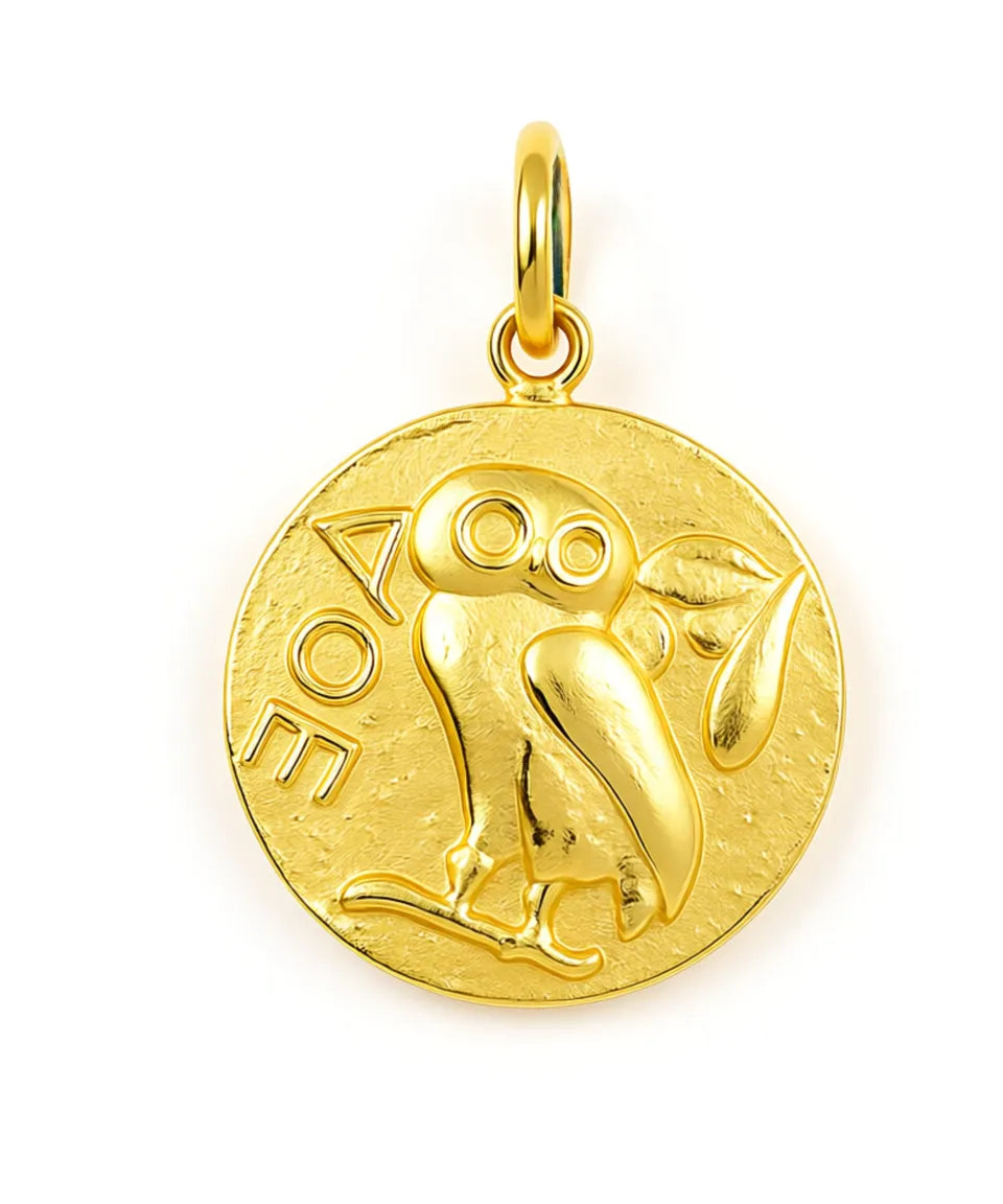 Gold pendant with an owl design on a white background