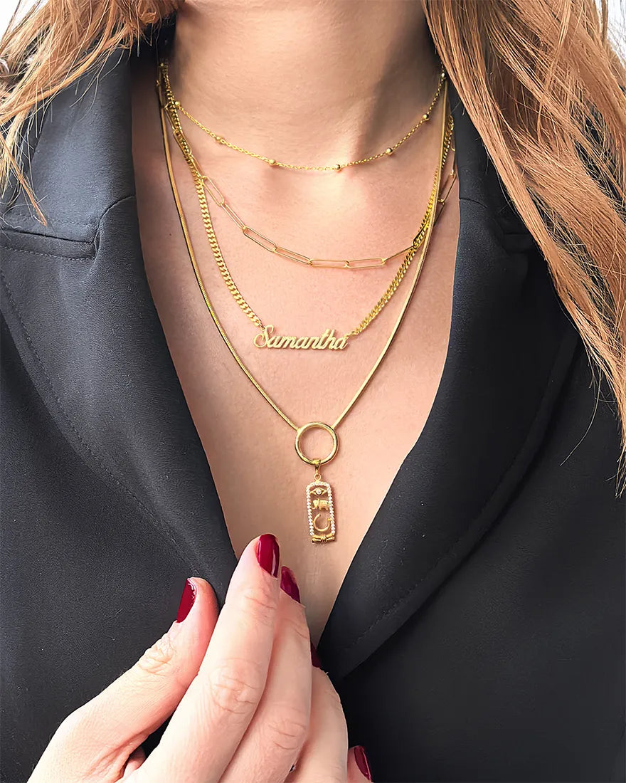 Model wearing layered gold vermeil necklaces with paperclip and name chain