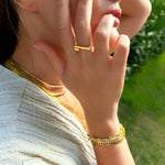 Close-up of a person wearing gold jewelry outdoors