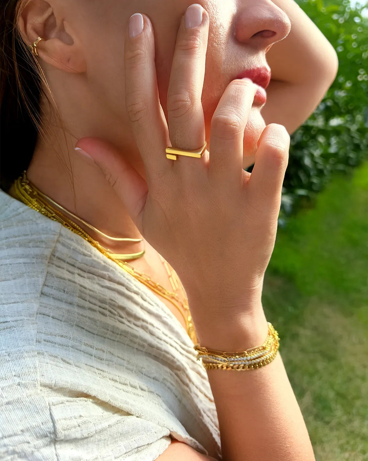 Close-up of a person wearing gold jewelry outdoors