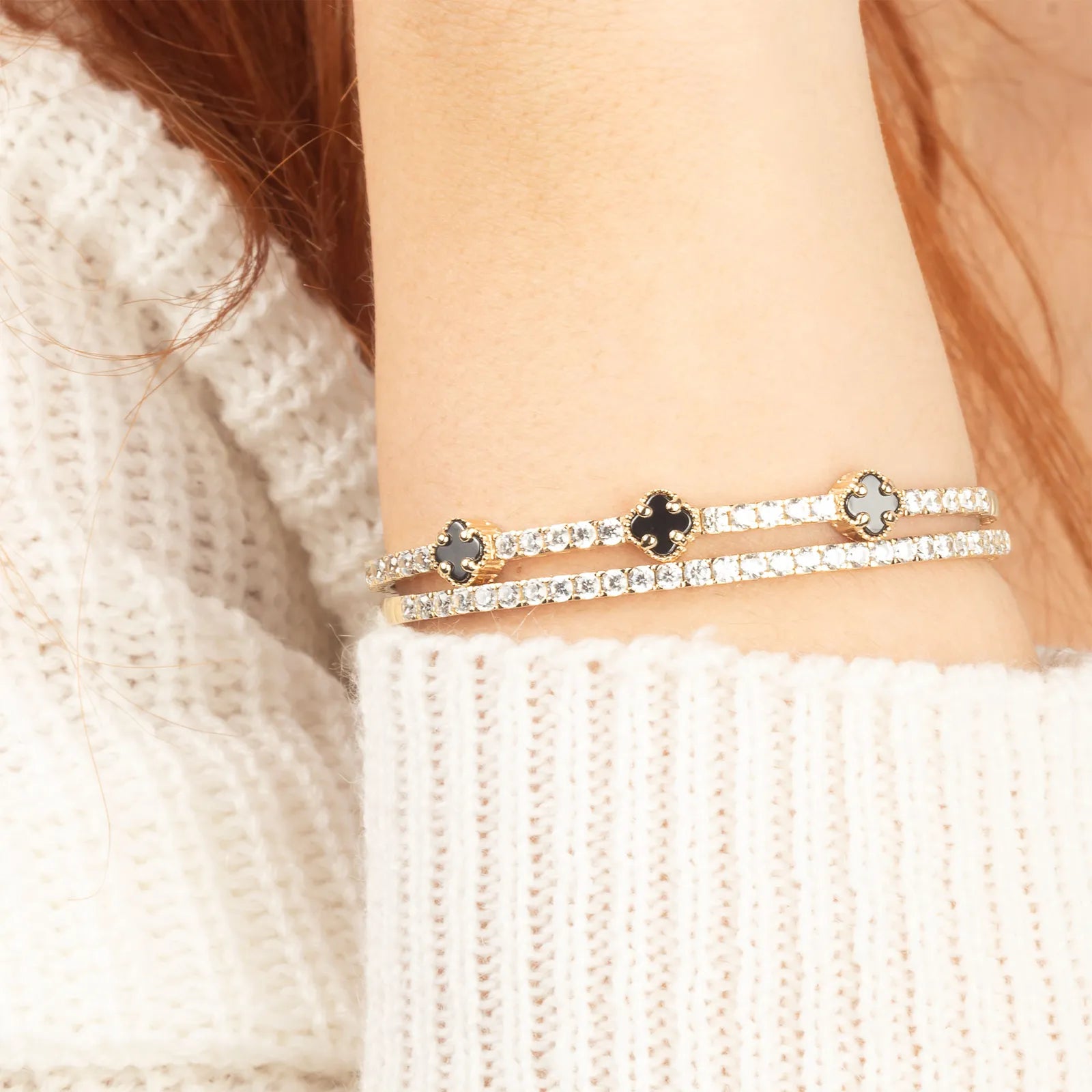stacked onyx clover bangle and diamond tennis bracelet on the model