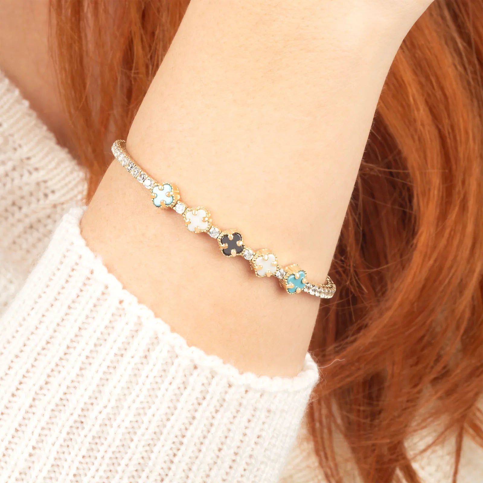 Bracelet with floral and cross charms on a wrist.| MyJewelist