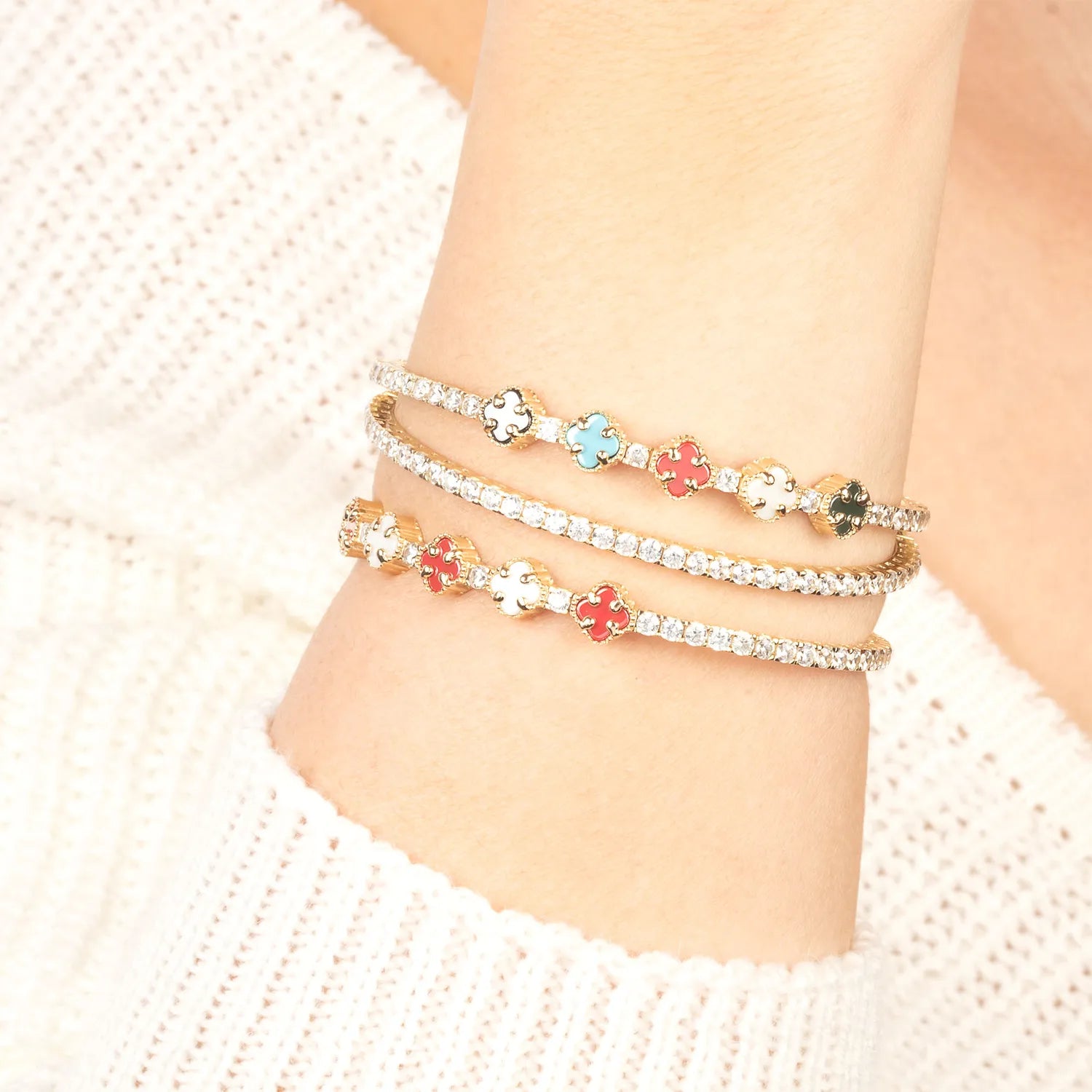Stack of three ankle bracelets with floral designs on a person's ankle.| MyJewelist